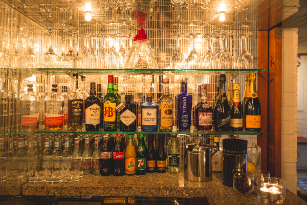 Elegant hotel bar with premium spirits, wine collection, crystal glasses under warm lighting, offering a cosy experience.
